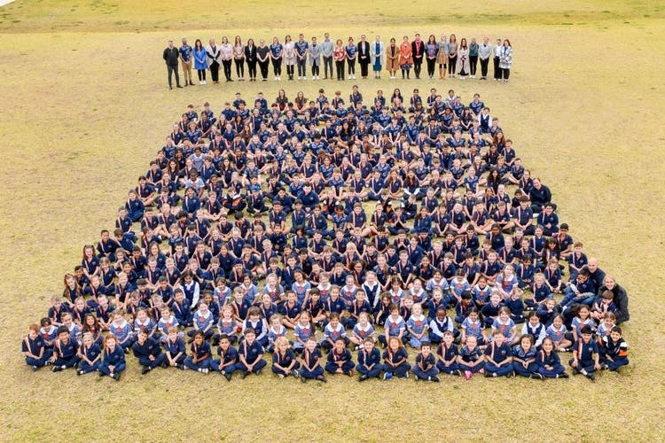 Picture of whole school sitting on the oval