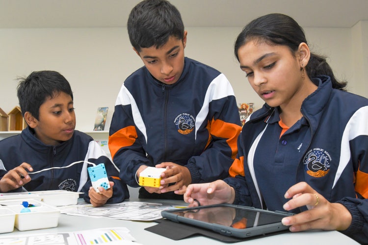 Three students working together to solve robotics challenges